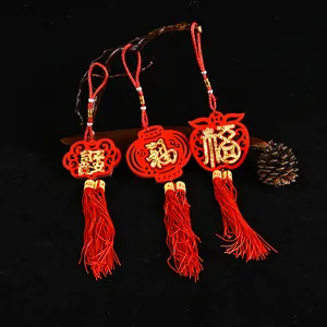 Close-up of traditional Chinese red felt ornaments with gold Fu characters and tassels.