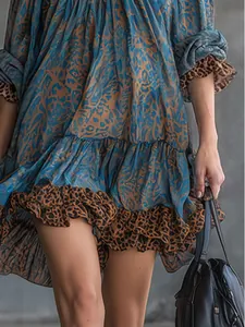 Close-up of retro leopard print and ruffled hem on a blue long sleeve mini dress