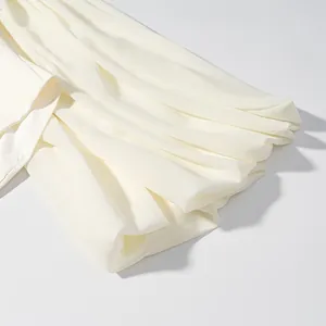 Close-up detail showing white flared sleeves with elegant pleated chiffon fabric texture