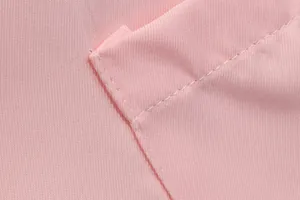 Macro view of pink women's blazer fabric highlighting refined stitching and texture