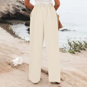 Vista posteriore dettagliata di pantaloni beige a vita alta da donna su sfondo spiaggia