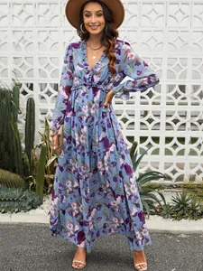Full-length view of a floral print long sleeve maxi dress in an outdoor setting
