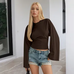 Ganzkörperaufnahme eines braunen Langarm-Tops mit eleganten weiten Ärmeln und schmaler Taille
