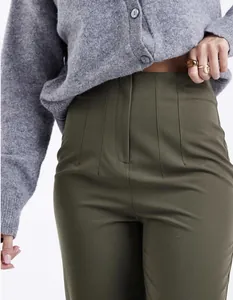 Close-up of olive green high-waisted trousers featuring elegant vertical seam details