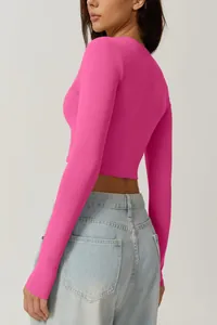 Vue latérale du haut court à manches longues rose vif pour femme porté avec un jean