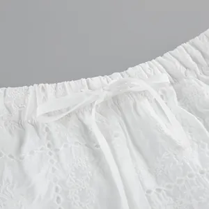 Gros plan sur la broderie anglaise blanche de la taille élastique avec cordon