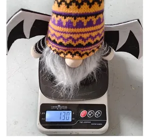 Halloween bat wing gnome plush toy shown weighing 130.9 grams on a digital scale