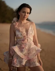 Elegant French style floral print mini dress with tiered ruffles shown on beach