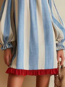 Close-up detail of blue striped vacation dress with puff sleeves and red ruffle trim