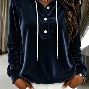 Close-up detail of a navy blue velvet hoodie featuring white buttons and drawstring cords