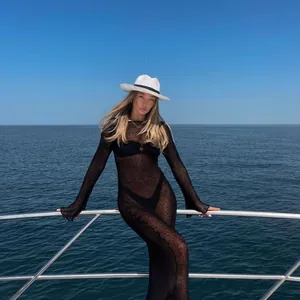 Sexy sheer black knit maxi dress beach cover-up worn by a model on a luxury boat