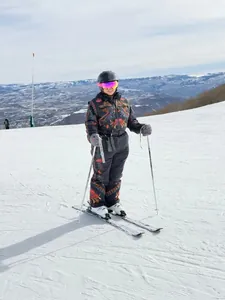 Full view of a vintage floral embroidered hooded one-piece ski suit shown in use