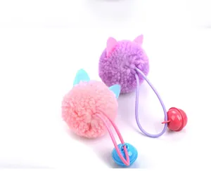 Gros plan de jouets pour chats en peluche avec balles roses et violettes et clochettes.
