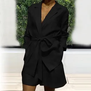 Detail of black two-piece leisure suit featuring a belted blazer and matching shorts.