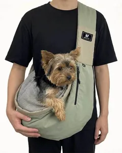 Detail view of the nylon pet sling carrier bag worn by a model with a small dog