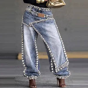 Detailed view of women's light blue deconstructed jeans with heavy rhinestone embellishments
