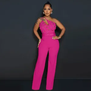Professional detail view of a pink one-shoulder jumpsuit with gold studs and belt