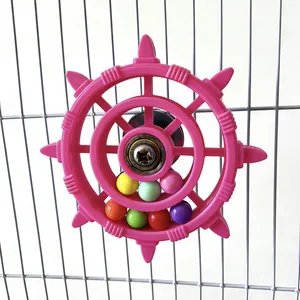 Detailed view of a colorful parrot ship wheel toy with spinning beads mounted on a birdcage