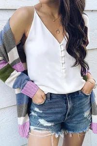 Detalle de un cárdigan de punto a rayas de colores con camisola blanca abotonada