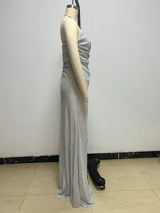 Side view of a sparkling silver spaghetti strap evening gown displayed on a dress form mannequin