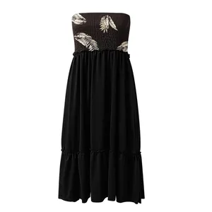 Detailed view of the pleated tube top with beige leaf print on this black midi dress.