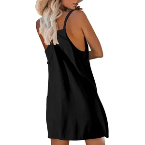Back view of a casual black sleeveless strappy mini dress on a model wearing a hat.