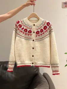Close-up of retro Fair Isle pattern on a soft cream knitted cardigan with buttons.