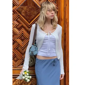 White crocheted hollow-out long sleeve cardigan with bow tie detail shown on model