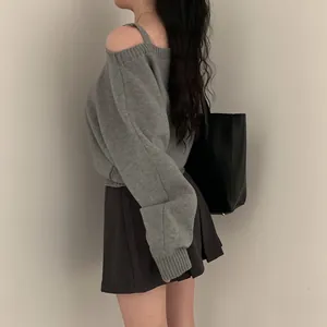 Dettaglio laterale di un maglione grigio lavorato a maglia con spalle scoperte e vestibilità