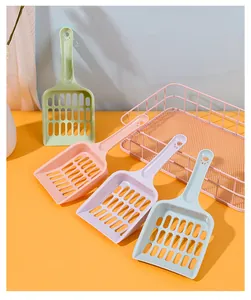 Macaron colored hollow cat litter scoops in various shades arranged on an orange table