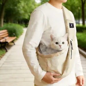 Portable cream pet sling carrier bag with a white cat in an outdoor park setting