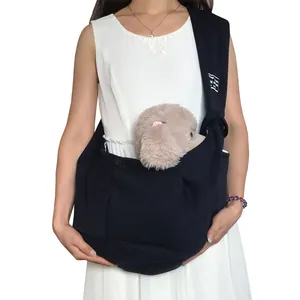 Adjustable black single shoulder pet sling carrier worn by model with plush toy dog