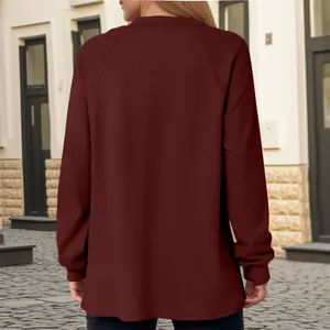 Achteraanzicht van een vrouw die een casual bordeauxrode sweatshirt met lange mouwen draagt