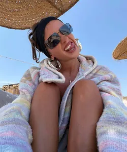 Detailed view of colorful striped hooded knit cardigan worn in beach vacation setting