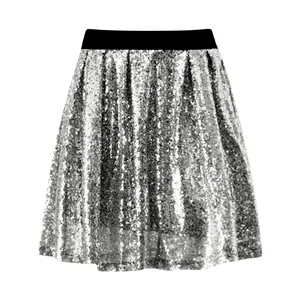 Dettaglio di paillettes argento scintillanti su una gonna a pieghe a vita alta