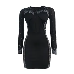 Detailed view of black bodycon dress with rhinestone patterns and sheer mesh sleeves
