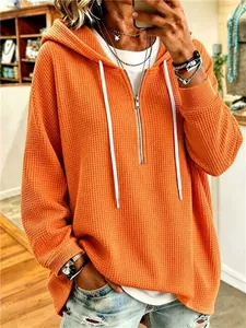 Loose orange waffle knit drawstring hoodie with front zipper for a casual style
