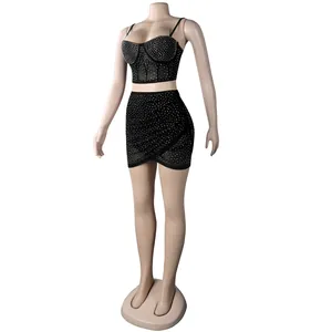 Conjunto sexy de dos piezas negro con pedrería, top bustier y falda mini a juego.