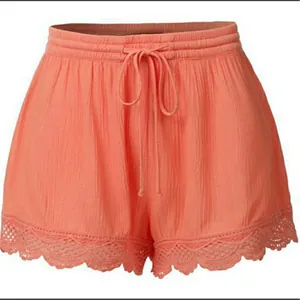 Détail de short d'été corail pour femme avec cordon de serrage et bordure en dentelle
