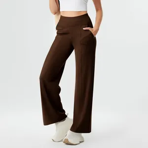 Full-length view of brown high-waisted yoga pants with functional pockets on model.