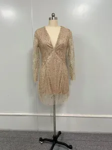 Abito a tubino con paillettes dorate, scollo a V profondo e maniche lunghe su manichino.