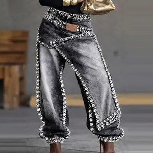 Detail of deconstructed high-waisted jeans with crystal borders and acid wash finish