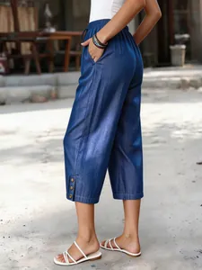 Detailansicht der blauen Tencel-Denim-Damenhose mit Knöpfen am Saum und Taschen