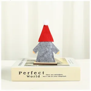 Handcrafted felt and wooden Christmas gnome figurine ornament on white decorative book