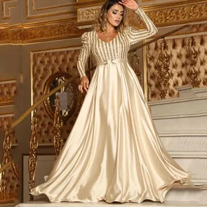 Elegant champagne gold V-neck evening gown with sequined long sleeves and satin skirt.