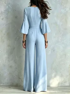 Back view of light blue wide-leg jumpsuit with flared sleeves and belted high waist