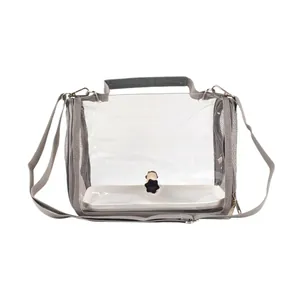 Full view of transparent bird travel carrier featuring internal wooden perch and grey shoulder strap