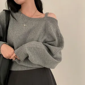 Dettaglio di un maglione grigio chic con spalla scoperta e vestibilità rilassata
