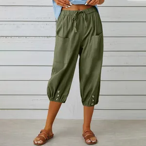 Loose cotton linen cropped pants with drawstring waist and button hem detail.
