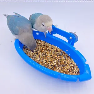 Zwei bunte Papageien fressen Samen aus einem blauen, schiffsförmigen Vogelfutterhaus.